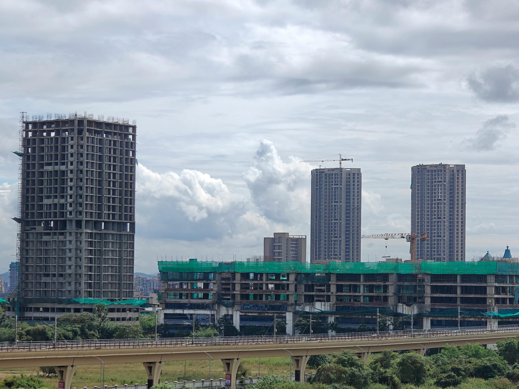 High-rise residential buildings under construction beside a highway
